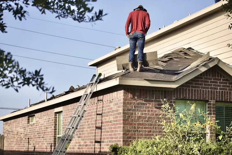 Professional roofer working on a residential roof in West Oaks Mall